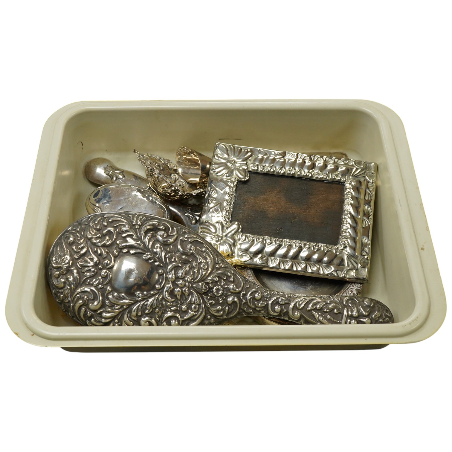 A small group of silver and white metal items, including an Edwardian silver and tortoiseshell mounted hand mirror by Samuel Jacob, 26.1cm, a silver mounted hair brush, a small silver mounted brush, a repousse silver pin